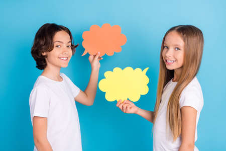Photo of two sociable kids communicate present mind cloud wear white t-shirt isolated blue color...