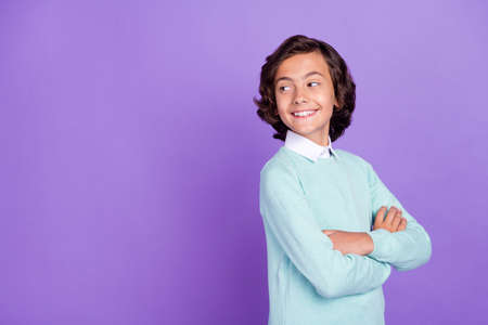 Profile photo of small cute brunet boy crossed arms look empty space wear blue sweater isolated on purple backgroundの写真素材