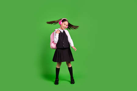 Full length body size view of attractive cheerful girl having fun listening hit isolated over bright green color backgroundの写真素材