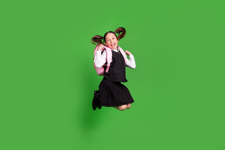 Full length body size view of nice trendy cheerful lucky girl jumping rejoicing isolated over bright green color backgroundの写真素材
