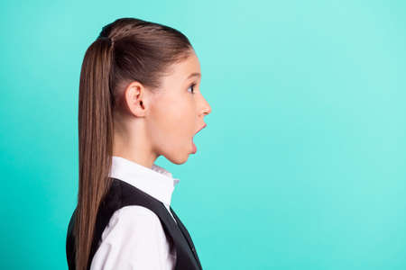 Side profile photo portrait little girl staring amazed opened mouth isolated pastel turquoise color backgroundの写真素材