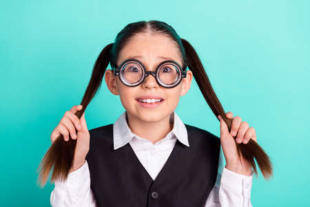 Photo portrait little girl wearing glasses keeping two ponytails isolated pastel turquoise color...