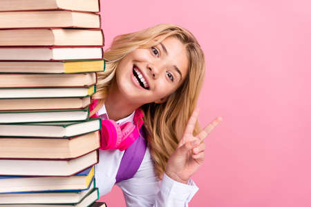 Photo of smiling funky pupil girl wear headphones showing v-sign studying schoolgirl isolated on...