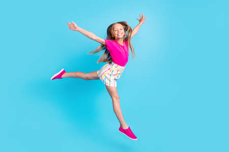 Full body photo of happy cheerful joyful small girl hands wings fly isolated on blue color...