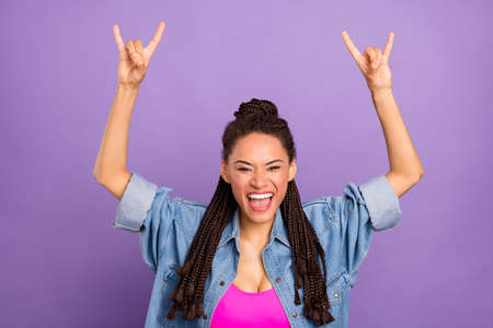 Portrait of attractive crazy cheerful girl showing double horn sign good mood isolated over bright purple violet red color backgroundの写真素材