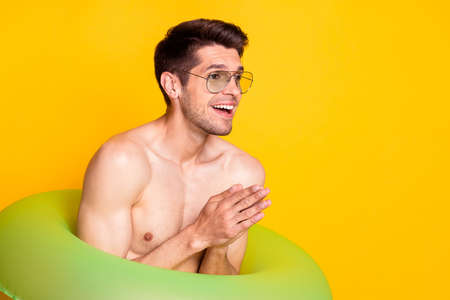 Photo of cool brunet millennial guy swim wear eyewear isolated on yellow color backgroundの写真素材