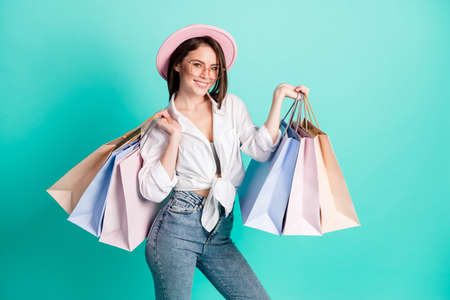 Photo of sweet cute young woman dressed white shirt cap shopping smiling empty space isolated teal...