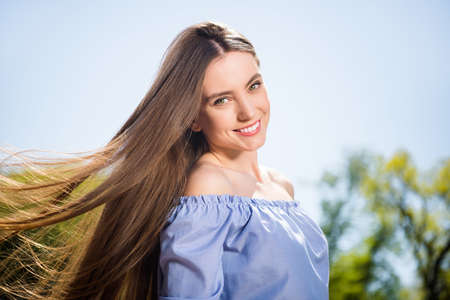 Profile side view portrait of attractive cheerful dreamy girl walking on fresh air holiday at downtown outdoorsの写真素材