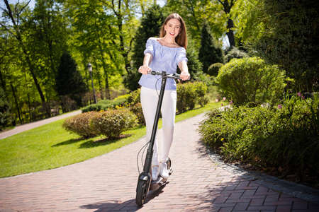 Full length body size view of attractive cheerful girl riding scooter having fun holiday vacation at...