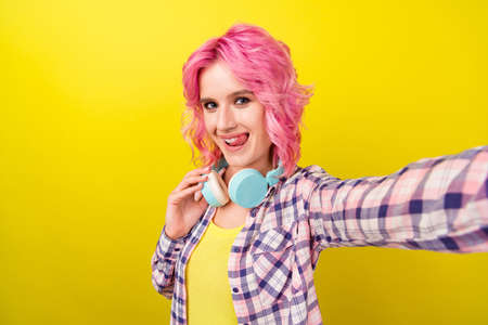 Photo of lovely pink hairdo young lady do selfie wear plaid shirt isolated on yellow color backgroundの写真素材