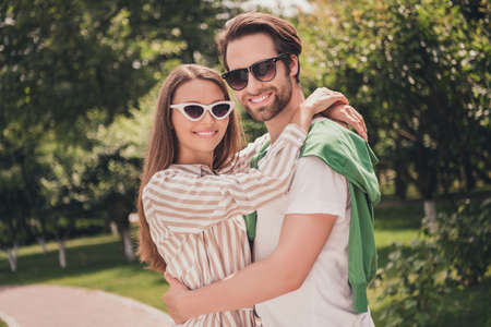 Photo portriat young couple smiling cuddling together having romantic date in green parkの写真素材