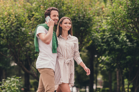 Photo portriat young couple smiling in summer wearing casual clothes man talking on mobile phoneの写真素材