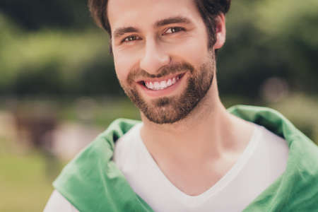 Cropped photo of young handsome cheerful man beard happy positive toothy smile sunny weather season outdoorsの写真素材