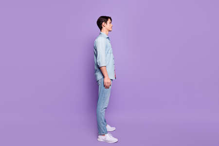 Full body profile side photo of young guy calm concentrated confident look empty space isolated over purple color backgroundの写真素材