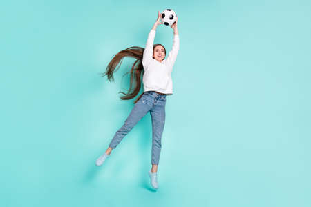 Full length body size view of pretty cheerful girl jumping catching ball isolated over bright teal...