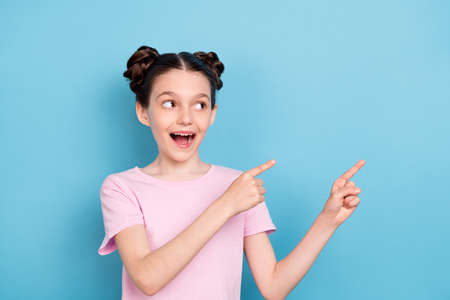 Photo of sweet impressed schoolgirl dressed pink t-shirt looking pointing finger empty space...