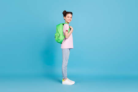 Full body profile side photo of happy little girl wear backpack student isolated on pastel blue...
