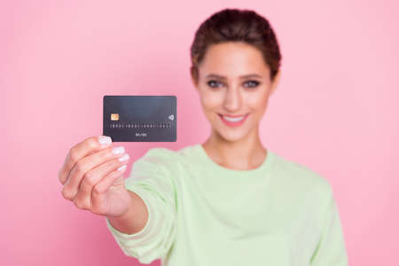 Photo of young girl happy positive smile show bank card buy purchase recommend isolated over pastel...