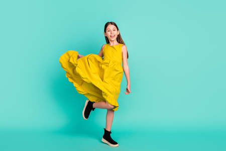 Full size photo of optimistic nice brown hair girl wear yellow dress shoes isolated on bright teal color backgroundの写真素材