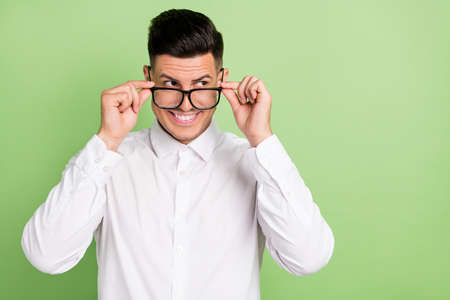 Photo of pretty funny young gentleman wear white shirt arms spectacles looking empty space isolated...