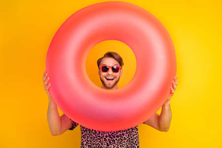 Photo of charming impressed young guy wear leopard outfit dark eyewear looking inflatable buoy...