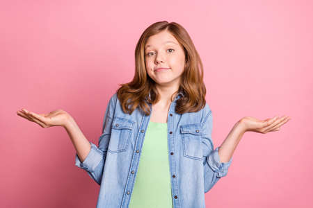 Photo of girl wearing jeans outfit isolated pastel pink color backgroundの写真素材