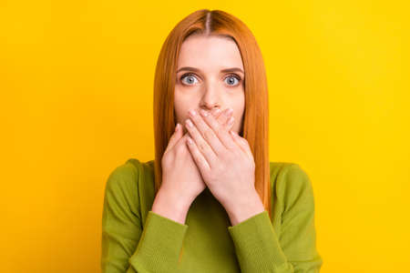 Photo of stressed ginger hair millennial lady close mouth wear green sweater isolated on yellow...