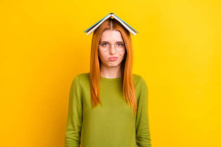 Photo of upset ginger hair millennial lady book on head wear eyewear green sweater isolated on...