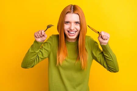 Photo of funny ginger hairdo young lady want to eat wear green jumper isolated on yellow color...
