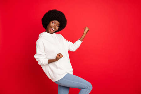 Photo of hooray brunette hair millennial lady hands fists wear white hoodie isolated on red color backgroundの写真素材