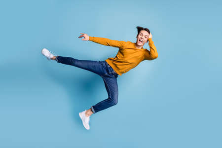 Full size photo of funny brunet young guy fight wear sweater jeans isolated on blue color backgroundの写真素材