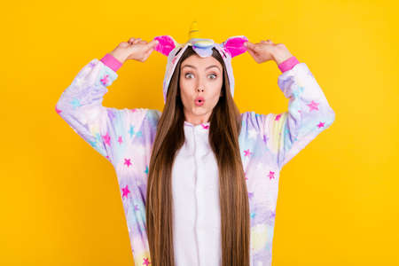 Photo portrait female teenager funny pajama keeping ears amazed isolated vibrant yellow background