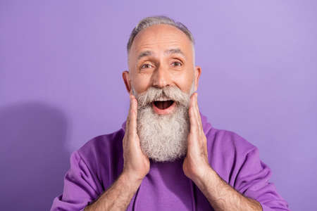 Portrait of attractive delighted cheerful grey-haired man great news reaction isolated over purple violet color backgroundの写真素材
