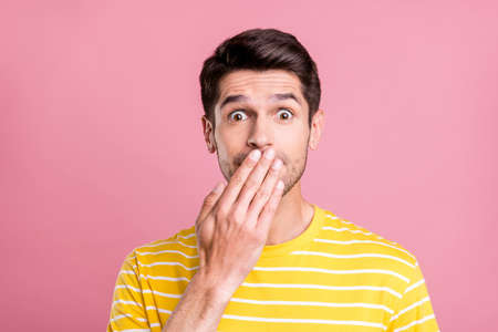 Photo of sad brunet millennial man close mouth wear yellow t-shirt isolated on pink color backgroundの写真素材