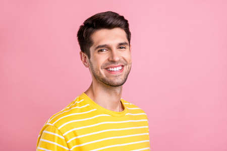Photo of young happy cheerful man smile good mood wear yellow t-shirt isolated on pink color...