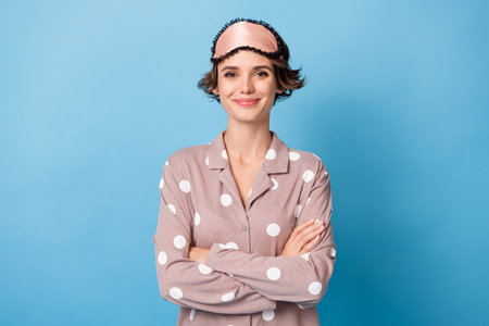 Photo of confident charming young woman folded hands wear sleepwear isolated on pastel blue color backgroundの写真素材