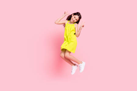 Full length photo of pretty funny schoolgirl dressed yellow outfit glasses jumping showing v-sign...