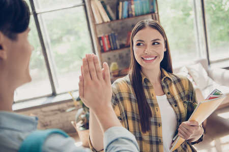 Portrait of two best friends classmates giving high five success celebrate triumph hold materials...