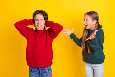 Photo portrait two children shouting arguing isolated bright yellow color background