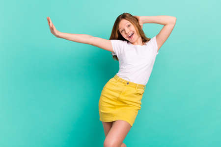 Photo portrait girl dancing at party overjoyed relaxing in casual outfit isolated vibrant teal color backgroundの写真素材