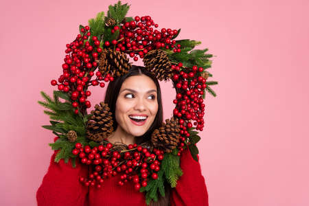 Photo of funny brunette lady hold wreth look empty space wear red pullover isolated on pink color backgroundの写真素材