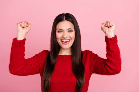 Photo of hooray brunette lady hands fists wear red pullover isolated on pink color backgroundの写真素材