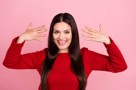 Photo of impressed brunette lady show nails wear red pullover isolated on pink color backgroundの写真素材