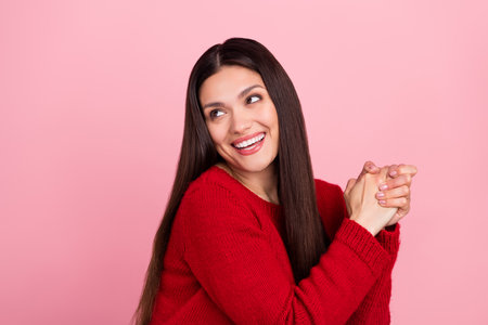 Photo of lovely brunette lady hold hands look empty space wear red pullover isolated on pink color backgroundの写真素材