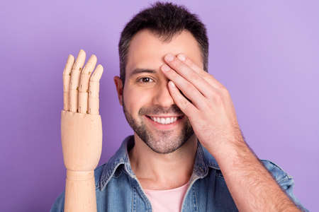 Photo of young man happy positive smile close eye hand show prosthesis amputee isolated over purple...