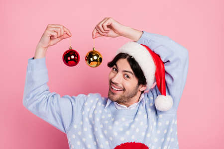 Photo of sweet handsome gentleman wear new year sweater smiling holding decoration balls isolated pink color backgroundの写真素材