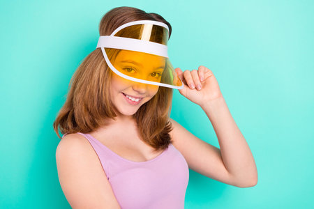 Photo portrait girl smiling cheerful wearing cap headband in summer isolated vivid teal color backgroundの写真素材