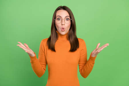Portrait of attractive amazed girl wearing specs sudden news reaction pout lips isolated over green color backgroundの写真素材