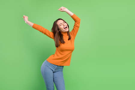 Portrait of attractive cheerful dreamy overjoyed girl having fun dancing clubbing isolated over green color backgroundの写真素材