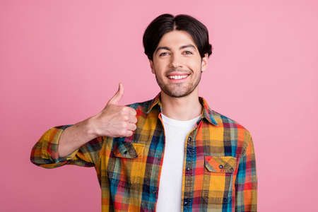 Photo of adorable attractive young gentleman wear plaid outfit showing thumb up smiling isolated pink color backgroundの写真素材